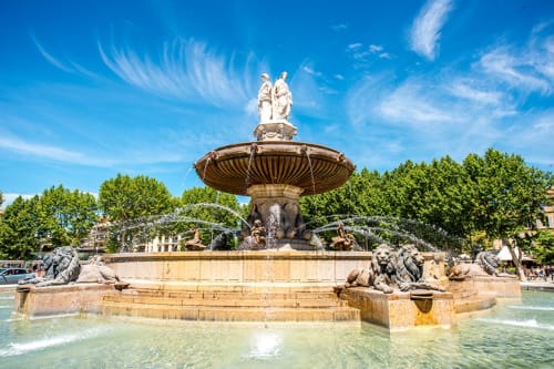 Fontaine ornementale historique avec sculptures de lions et statue centrale sous un ciel bleu, Venelles France