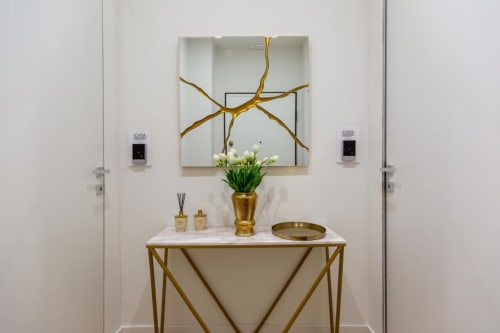 Elegante ingresso di Casa Lounge Istria Cagliari con consolle in marmo, specchio botanico dorato e fiori freschi