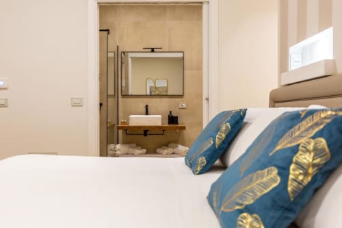 Camera da letto presso Casa Lounge Istria a Cagliari con bagno ensuite, cuscini blu a motivi e arredi moderni