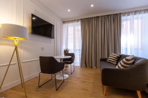 Suite moderna a Casa Lounge Istria a Cagliari con salotto, TV a schermo piatto e tende da pavimento a soffitto