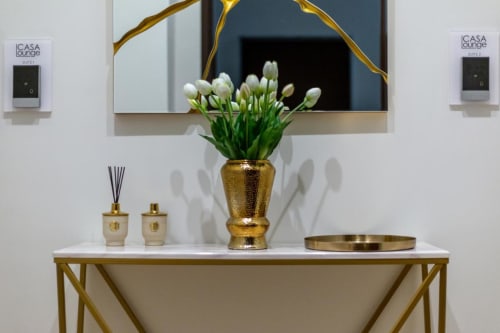 Elegante ingresso di CASA LOUNGE ISTRIA a Cagliari con tulipani bianchi in vaso dorato, specchio e arredi di lusso