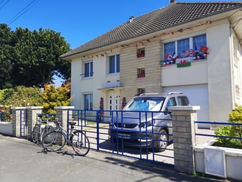 Au Gite d'Isigny B&B à Isigny-sur-Mer : maison moderne deux étages, portail bleu, voiture garée et vélo.