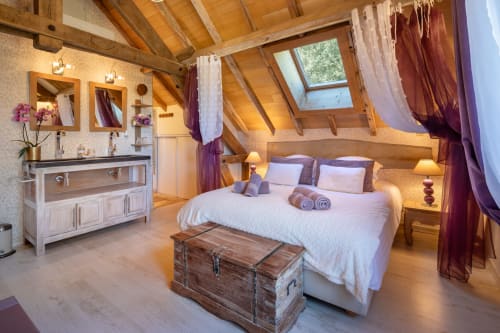 Luxe zolderslaapkamer met blootliggende balken, tweepersoonsbed, dubbele wastafel en tuinuitzicht in Domaine De Campagnac