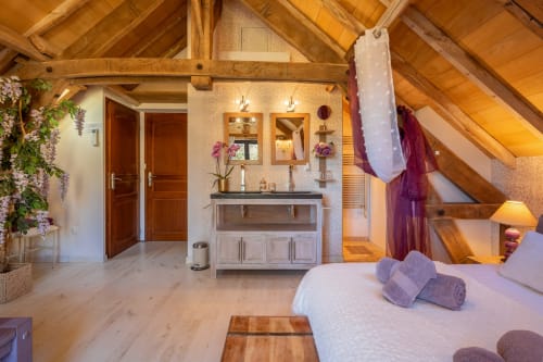 Luxe slaapkamer suite op Domaine De Campagnac met zichtbare houten balken, eigen badkamer en tuinuitzicht