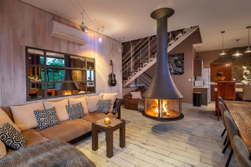 Modern woonkamer in Domaine De Campagnac met open haard, sofa en tuinuitzicht in Carsac-Aillac