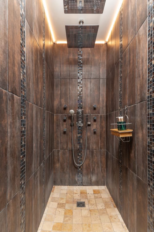 Moderne luxe badkamer met donkere houtlook tegels, regendouche en sfeerverlichting in Domaine De Campagnac