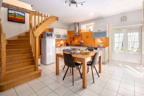Moderne keuken en eetkamer in Opaline-kamer in Domaine De Campagnac, Carsac-Aillac met houten trap en oranje spatwand