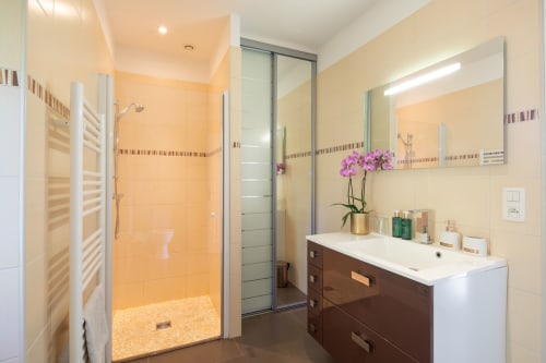 Moderne badkamer in de Opaline kamer van Domaine De Campagnac met verwarmde handdoekstang, wastafel en inloopdouche