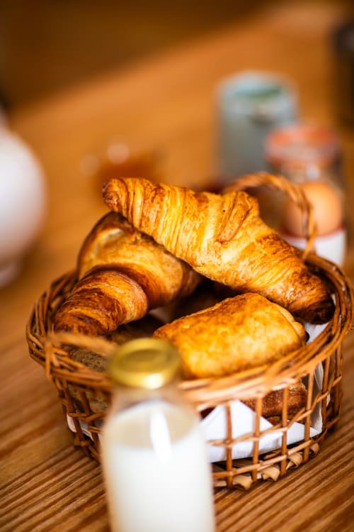 Gouden croissants in een rotan mandje bij het ontbijt van Domaine De Campagnac, Carsac-Aillac