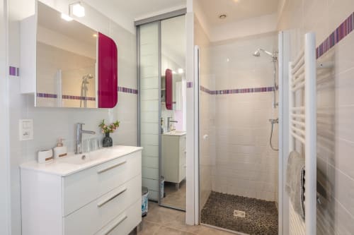 Moderne badkamer in Domaine De Campagnac met witte wastafel, paarse accenten, inloopdouche en verwarmde handdoekrekken