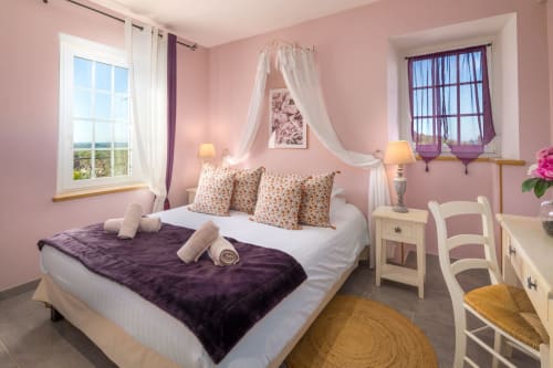 Cocoon-slaapkamer in Domaine De Campagnac met roze muren, hemelbed en uitzicht op het zwembad