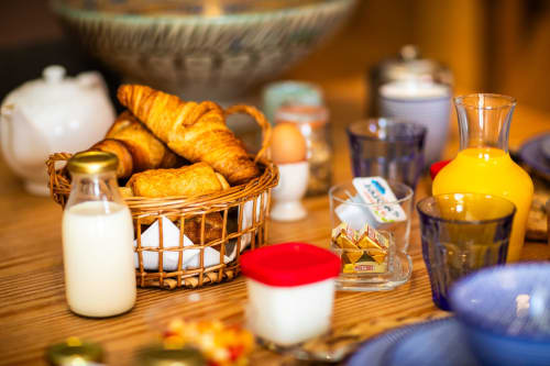 Ontbijttafel bij Domaine De Campagnac B&B in Carsac-Aillac met verse gebakjes, melk, sap en tafelschikking