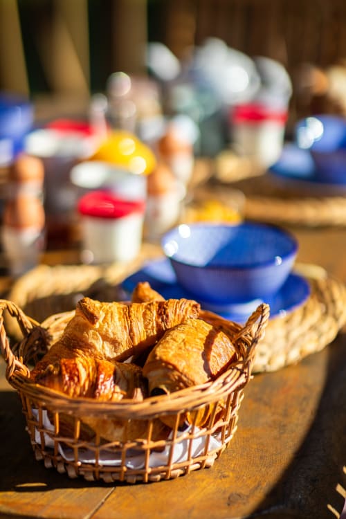 Croissants dans un panier en osier au petit-déjeuner du Domaine De Campagnac à Carsac-Aillac