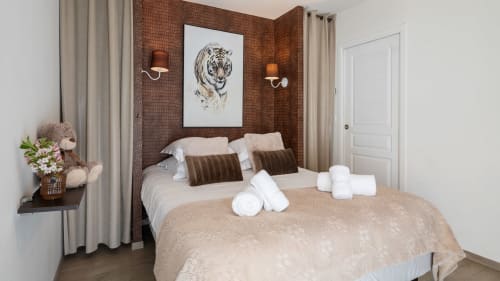 Slaapkamer Le Catalpa cottage in Domaine De Campagnac met bakstenen accentmuur, tigerkunstwerk en tuinuitzicht
