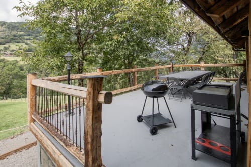 Terrasse extérieure du Domaine de l'Epigny avec barbecue, places assises et vue panoramique sur la vallée