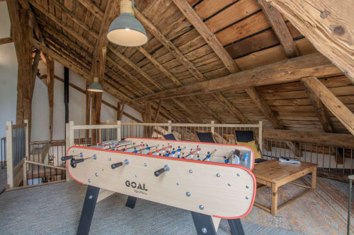 Salle de jeux récréative du Domaine de l'Epigny avec baby-foot et plafond à poutres en bois à Grand Aigueblanche