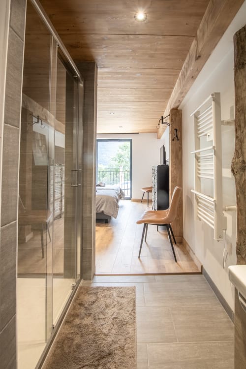 Couloir de salle de bains moderne au Domaine de l'Epigny avec douche à l'italienne, plafond en bois et vue sur les montagnes