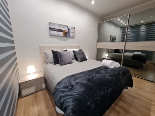 Camera moderna Raymihome Torino con letto queen, armadio a specchio, parete a righe e arredamento contemporaneo