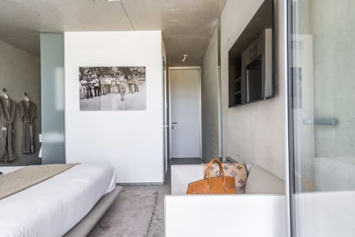 Modernes Hotelzimmer im Le Pavillon M in Grignan mit Queensize-Bett, minimalistischer Einrichtung und Badezimmereingang