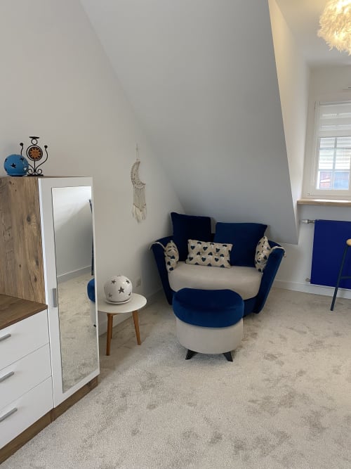 Chambre moderne de la Lady Jule B&B à Sainte-Luce-sur-Loire avec fauteuil bleu marine, pouf crème et décoration contemporaine