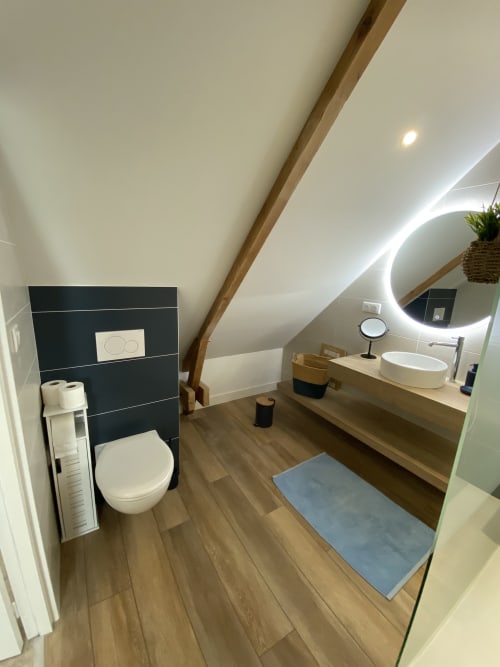 Salle de bain ensuite moderne au Lady Jule B&B à Sainte-Luce-sur-Loire avec vasque design, miroir rétroéclairé et accents en carrelage foncé