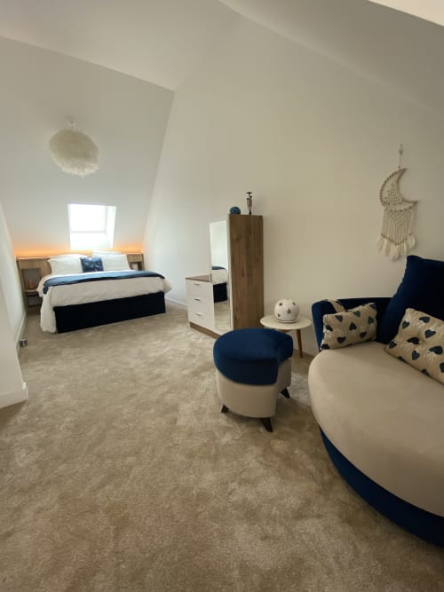Chambre moderne aux accents bleu et crème aux Chambres d'hôtes Lady Jule, avec lit, coin salon et décoration macramé