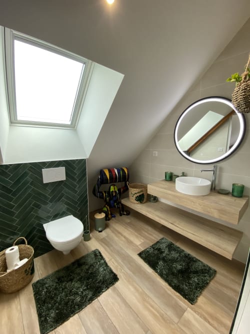 Salle de bain mansardée moderne aux Chambres d'hôtes Lady Jule avec carrelage vert, miroir rond, puits de lumière et vanité en bois