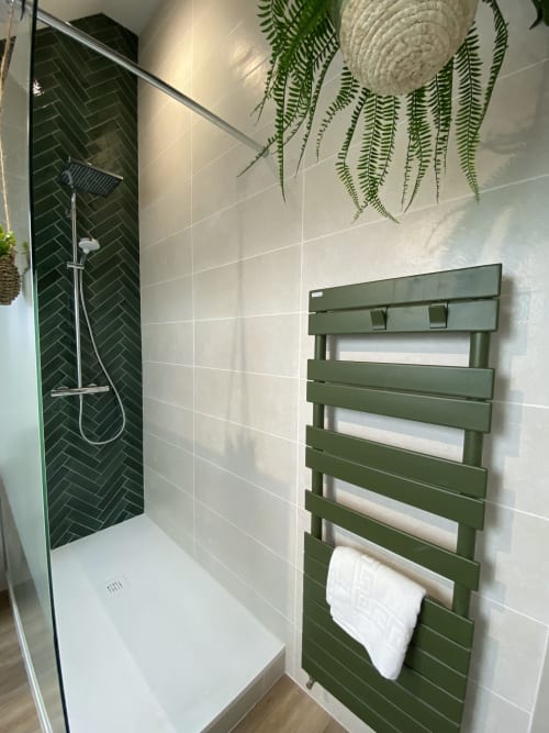 Salle de bain moderne avec carrelage en chevrons vert, murs blancs, sèche-serviettes chauffant, plantes suspendues et douche à l'italienne chez Lady Jule