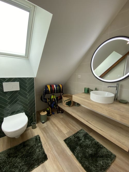 Salle de bain moderne aux Chambres d'hôtes Lady Jule : puits de lumière, carrelage vert en chevron, miroir rond, vasque en bois et spa