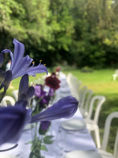 Flores púrpuras adornan una mesa al aire libre en Domaine de l'Ocrerie en Pourrain, Francia