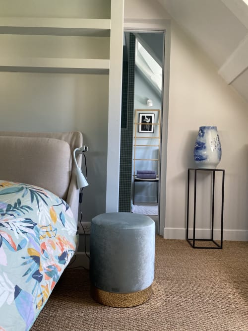 Chambre Colette à La Guirtelle, Lainsecq : lit, pouf gris, vase bleu et miroir.