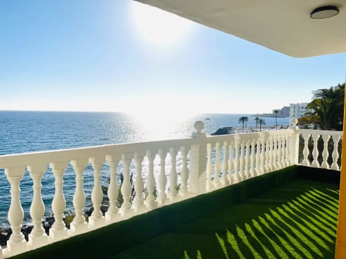 Oceanfront balcony with white balustrade overlooking Mediterranean Sea, Arguineguín hotel suite with sea view and palm trees