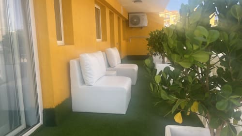 Modern terrace with white seating, green artificial turf, and lush plants at Sunset ocean view hotel suite in Arguineguín,