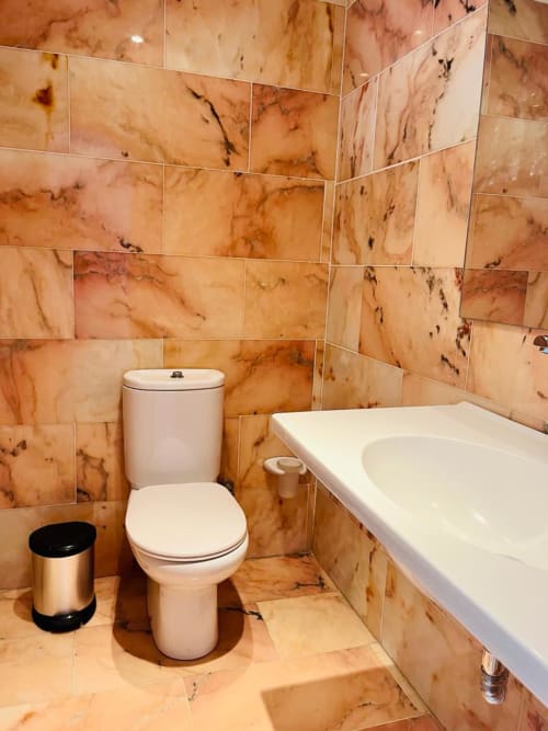 Modern bathroom with marble-effect tiles, white toilet, sink, and bathtub in Arguineguín hotel suite