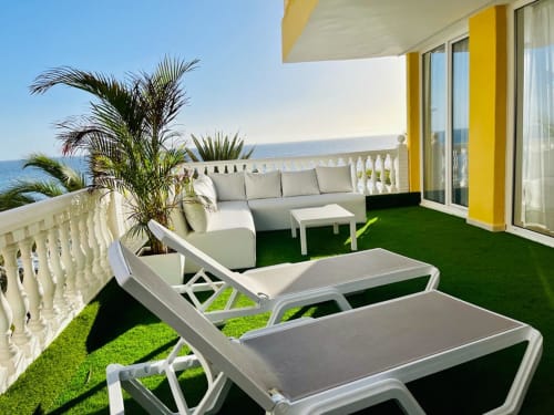 Seaside terrace in Arguineguín with loungers, seating area, palm plant, and ocean view