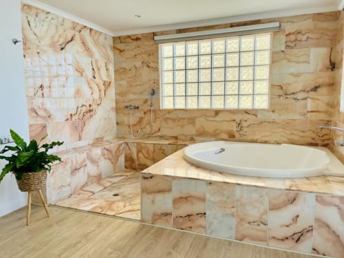 Luxurious marble bathroom with soaking tub, walk-in shower, and large window at Sunset ocean view hotel suite