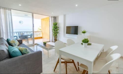 Modern 1-bedroom apartment in Arguineguín with sea view, dining area, furnished balcony, TV, and ocean-facing windows