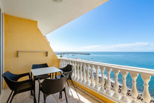 Balcony with sea view at Sunset ocean view hotel in Arguineguín, black chairs and table overlooking Mediterranean