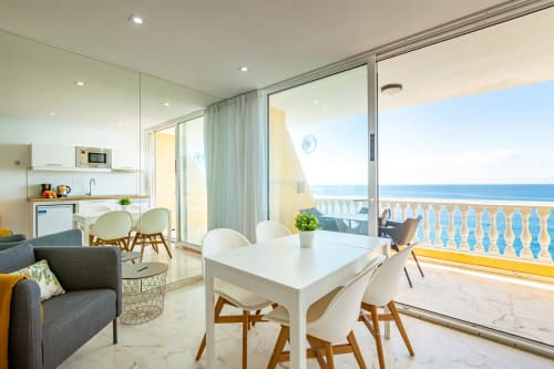 Modern Double Studio apartment at Sunset ocean view with sea view balcony, dining table, kitchen, and sofa in Arguineguín, ES