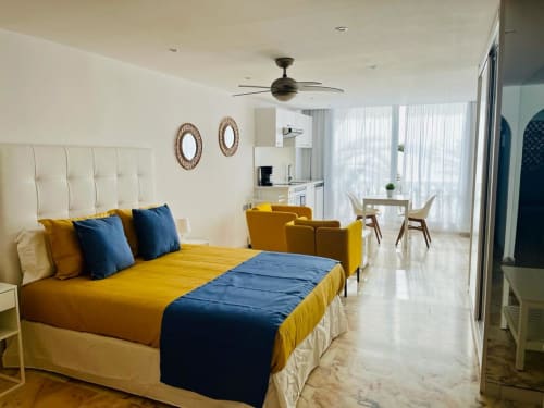 Modern studio apartment with yellow and blue accents, ocean views, ceiling fan, and sea-view balcony in Arguineguín