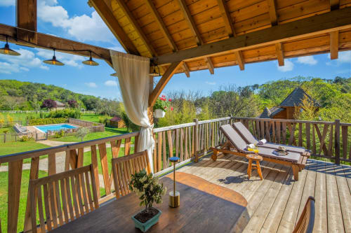 Mayreau-kamer in Domaine De Campagnac met houten pergola, ligstoelen en uitzicht op het zwembad in Carsac-Aillac