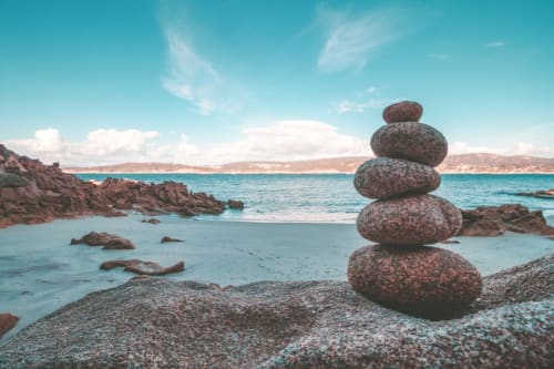 Rochers empilés sur une plage rocheuse avec mer turquoise et falaises côtières près de la vallée de la Loire