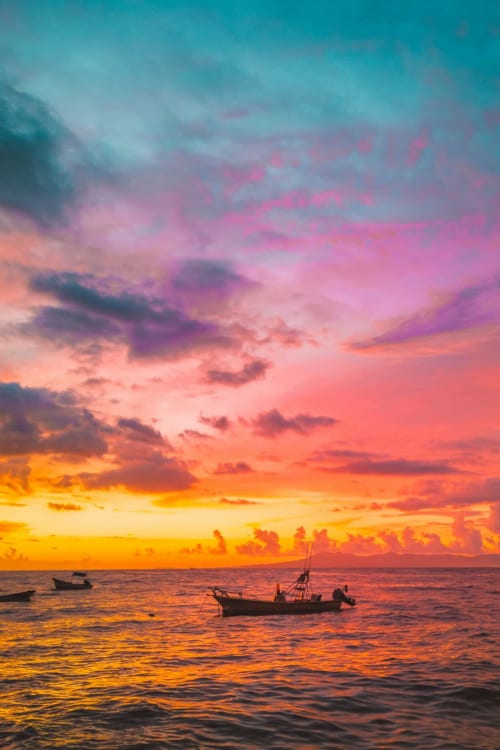 Colorful sunset over ocean with fishing boats, Arguineguín coastal view