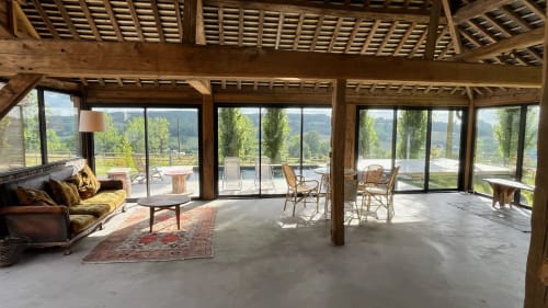 Spacious open-plan lounge with wooden beams, large glass doors overlooking valley views at Domaine de Blanvatel, Saint Pierre