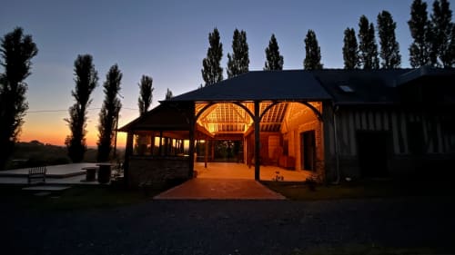 Domaine de Blanvatel B&B at dusk, illuminated buildings with tall poplar trees in Saint Pierre en Auge, France