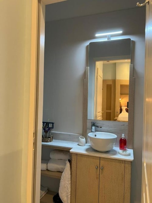 Bathroom equipped with shower, sink and mirror and toilet.