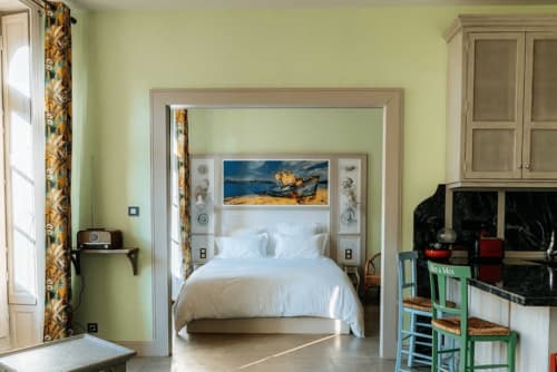Bright bedroom at Mes à Moi Pézenas with white bedding, pale yellow walls, and golden artwork in Pézenas, France