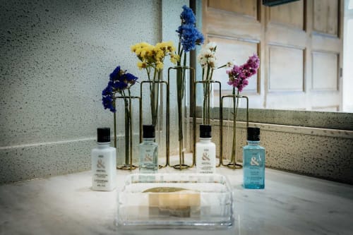 Luxury bathroom amenities display at Mes à Moi Pézenas with colorful flowers in glass vases and L'Occitane products