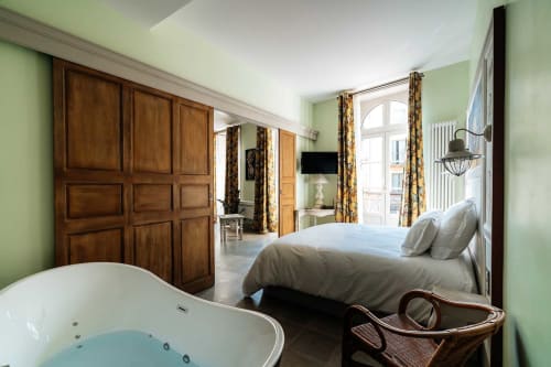 Chambre de luxe avec jacuzzi au Mes à Moi Pézenas B&B, armoire en bois, mur miroir et touches vert pâle