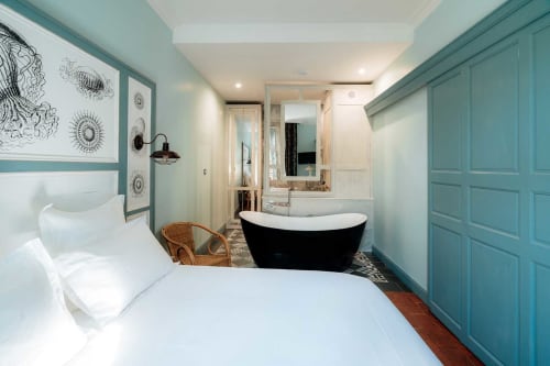Chambre avec salle de bain privée à Mes à Moi Pézenas : murs turquoise, literie blanche et baignoire îlot noire